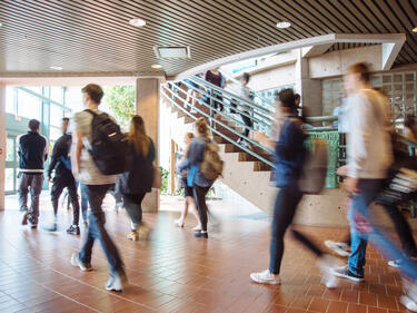 Blurred students walking to class through front foyer of school